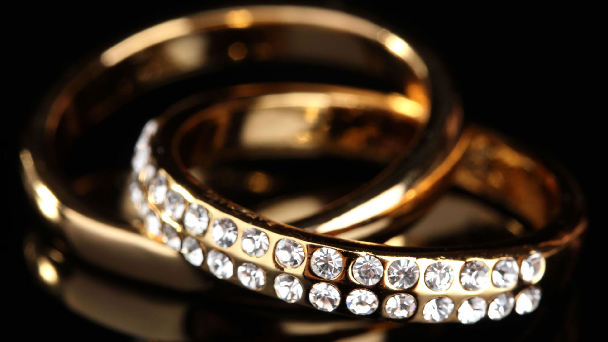 Ремонт золотого кольца. Ювелирные украшения. Кольцо на черном фоне. Красивые обручальные кольца с бриллиантами. Ювелирные изделия на черном фоне.